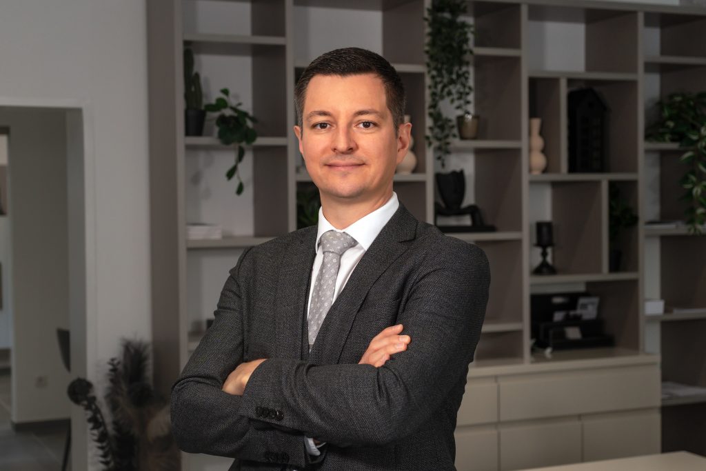 David Deindl, Gesch&auml;ftsf&uuml;hrer und Immobilienberater bei David Deindl Immobilien, l&auml;chelnd im B&uuml;ro
