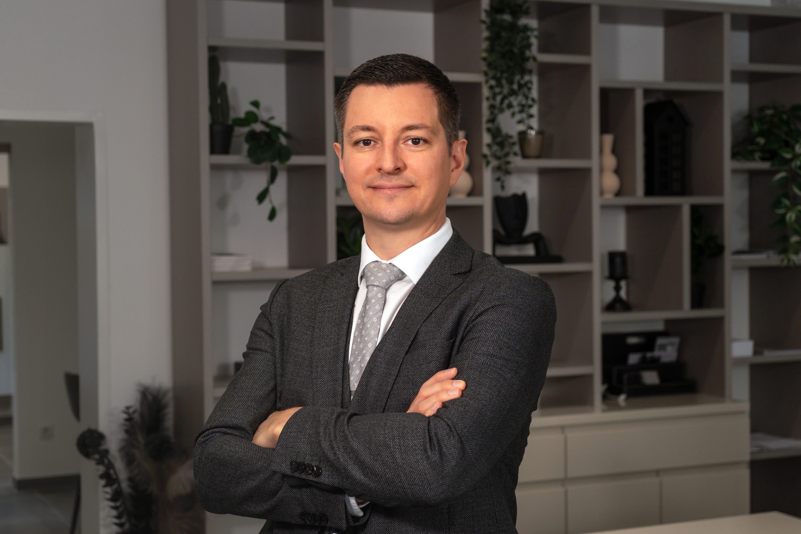 David Deindl, Gesch&auml;ftsf&uuml;hrer und Immobilienberater bei David Deindl Immobilien, l&auml;chelnd im B&uuml;ro
