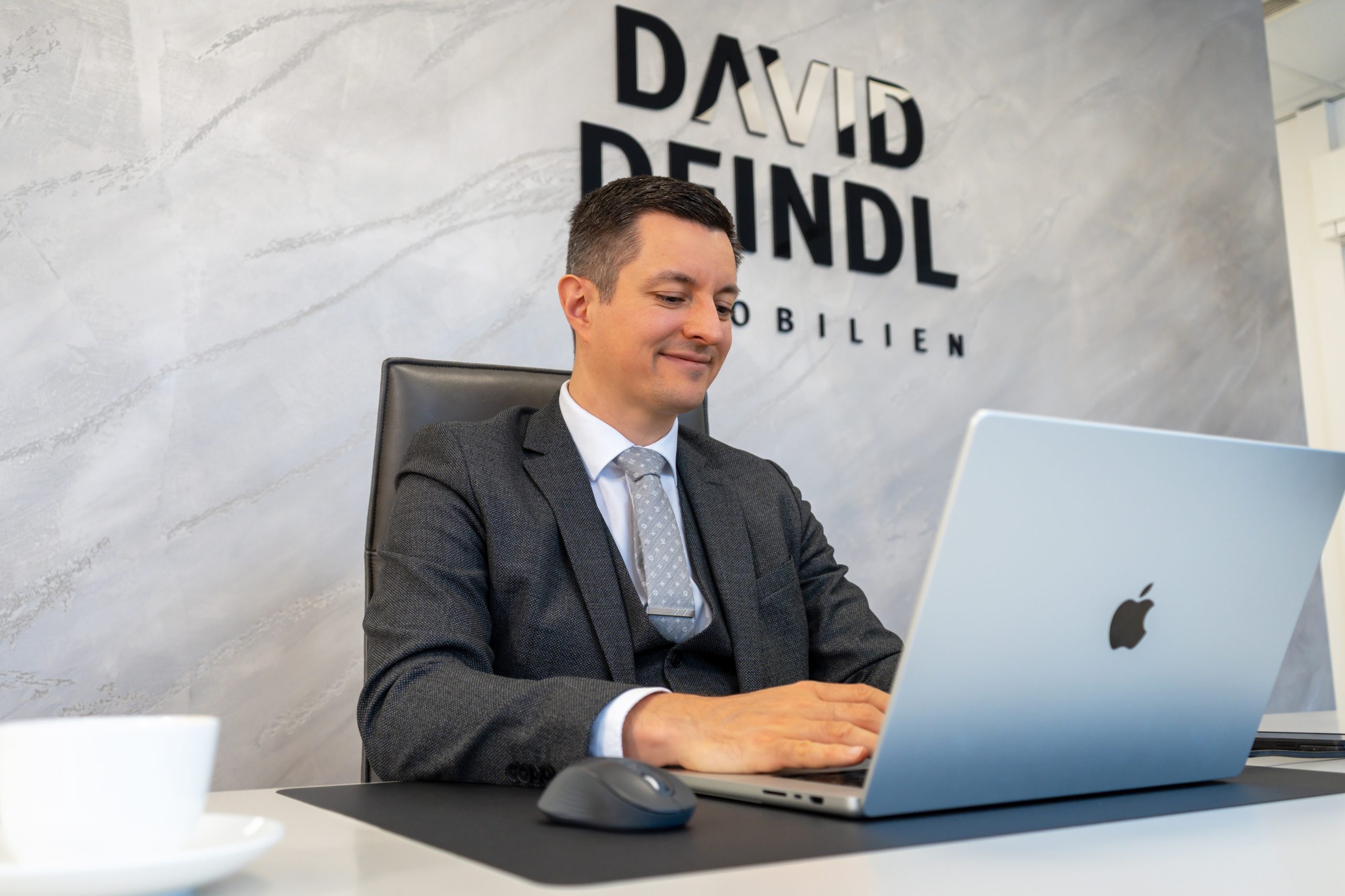 David Deindl, Gesch&auml;ftsf&uuml;hrer und Immobilienberater bei David Deindl Immobilien, arbeitet auf Laptop