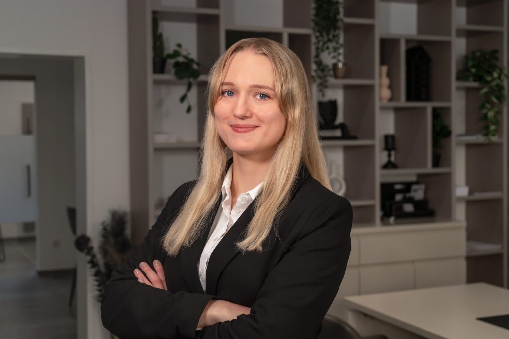 Julia Kaindl, Marketing Managerin bei David Deindl Immobilien, l&auml;chelnd im B&uuml;ro