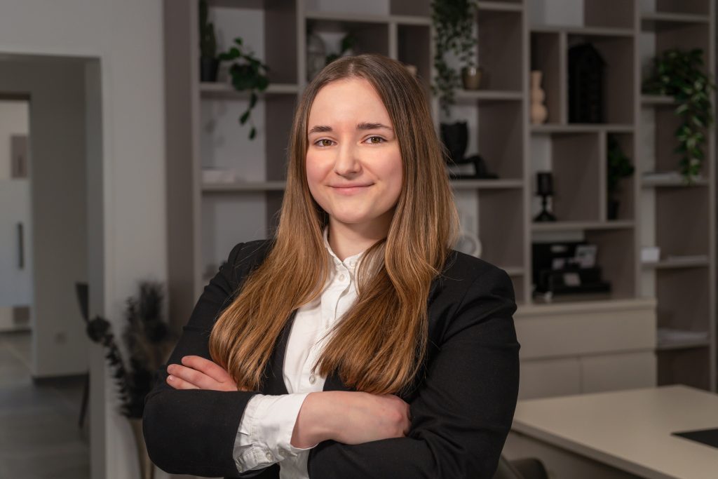 Julia Reiter, Back Office Managerin bei David Deindl Immobilien, l&auml;chelnd im B&uuml;ro