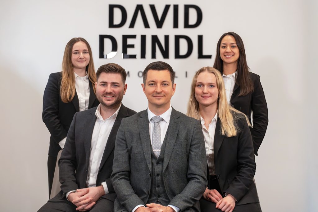 Team von David Deindl Immobilien vor dem Firmenlogo in Salzburg